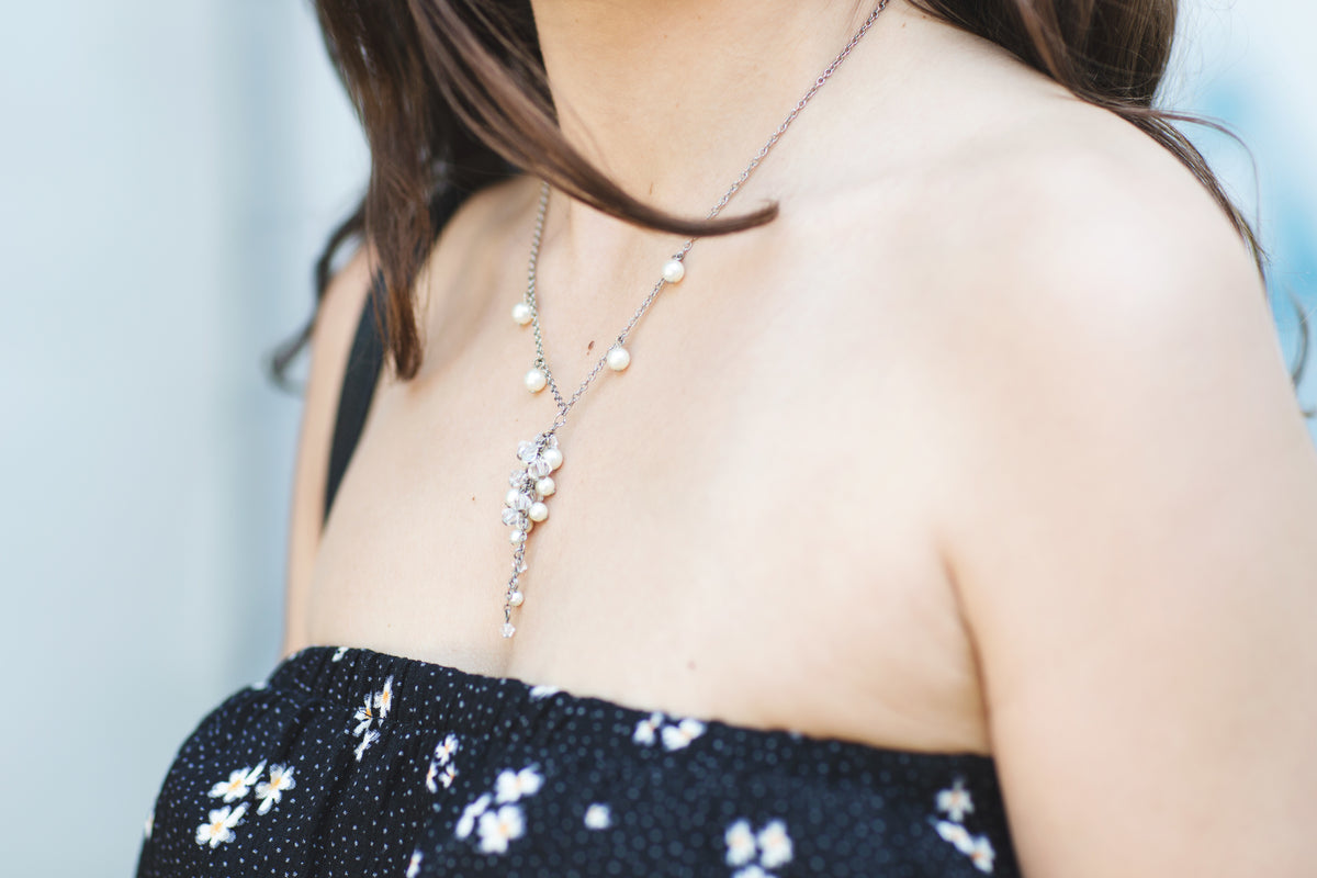 Mujer con un collar de cadena fina sobre blusa oscura